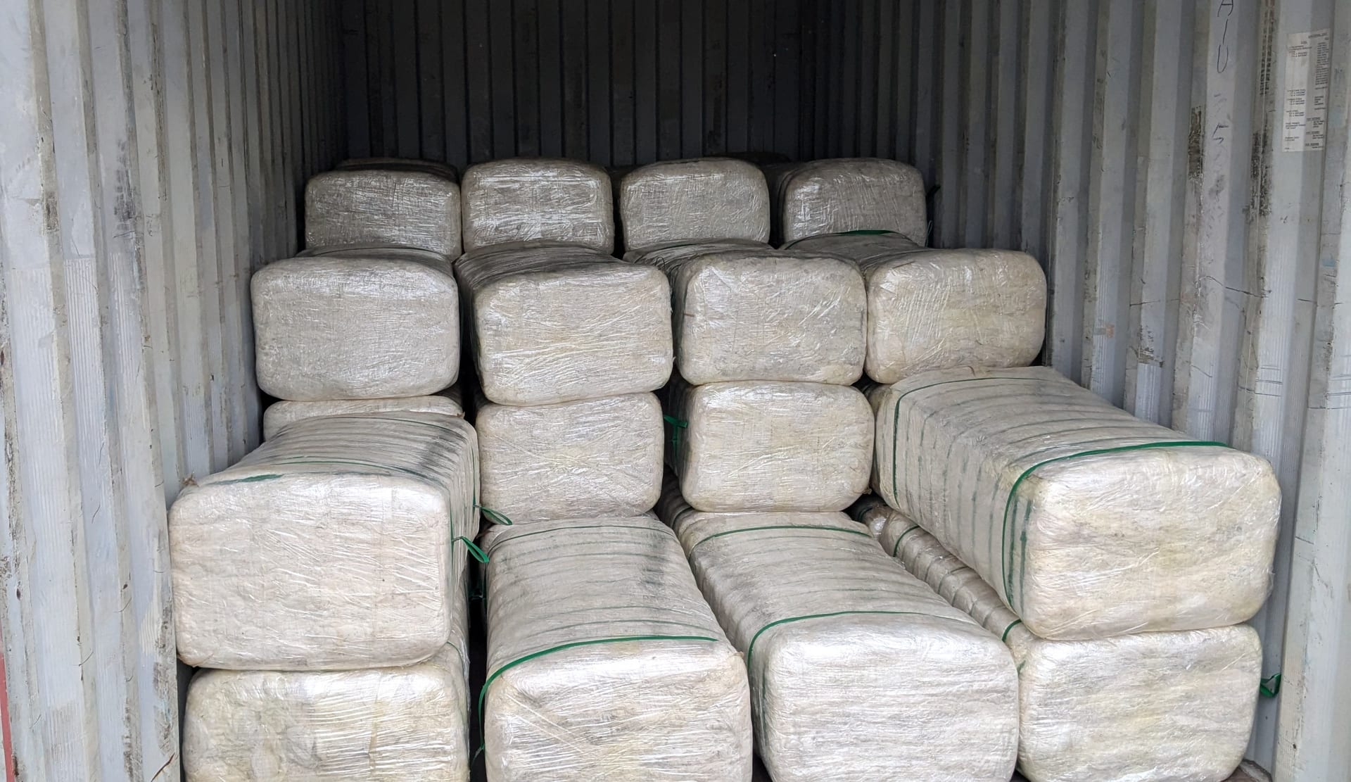 Wrapped bales of pineapple fibre loaded in a shipping container for export